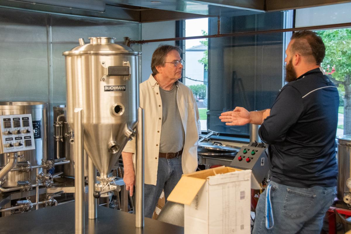 Graphic arts grad Karl Foor, ’77 (left), checks out the brewing & fermentation lab, helped by Brian D. Walton, assistant dean of business & hospitality.