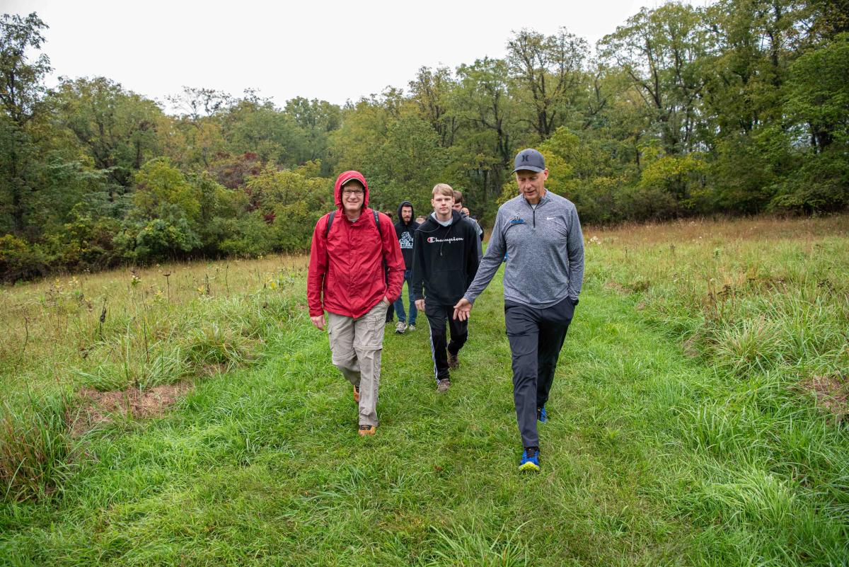 Leading the pack and enjoying a chat with the president are Brady C. Dunn (at center in black), a first-year diesel technology student from Andover, Mass., and his father.