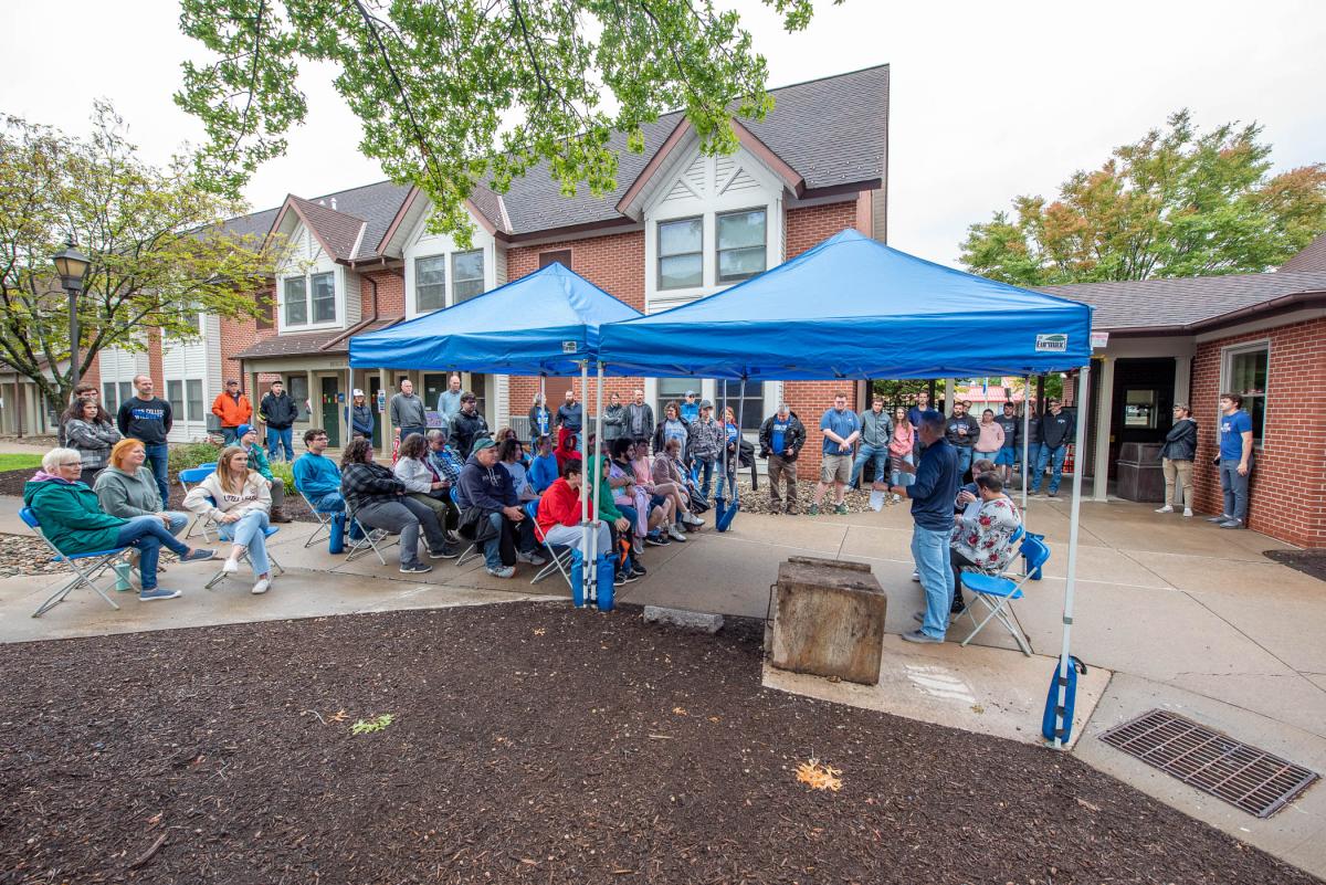 A crowd gathers in The Village courtyard, as Timothy J. Mallery (standing to the right of the time capsule), assistant director of residence life and housing operations, serves as “master of ceremonies." 