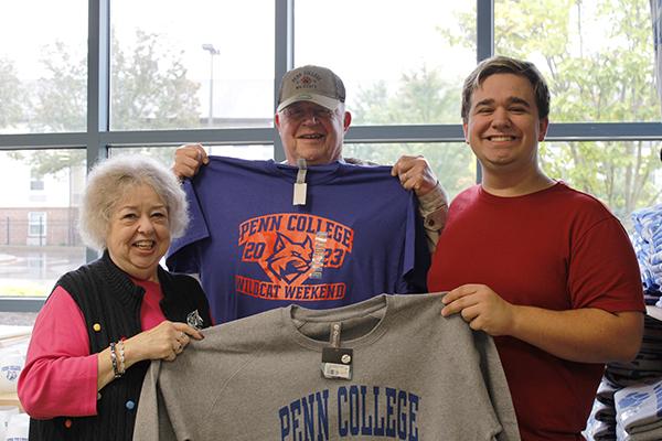 Colin J. Shay and grandparents hold up Penn College apparel – including the limited-edition Wildcat Weekend T-shirt (center) – in The College Store. Shay, of Blandon, is enrolled in engineering design technology.
