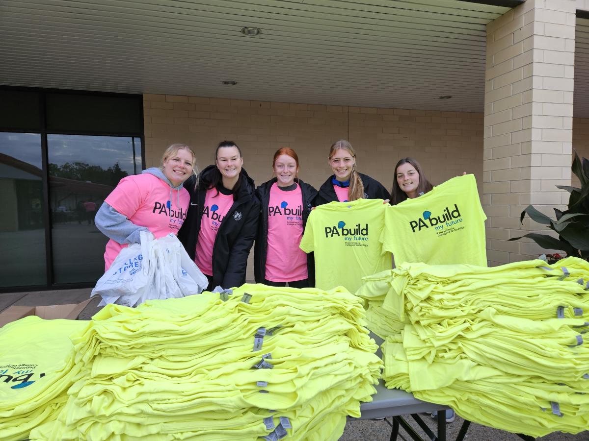 Helping with T-shirt distribution on the south side of West Third Street are members of the Penn College women's soccer team. From left are Virginia R. Yost, BillieGean D. Hennessy, Teagan A. Willey, Rylee N. Oliphant and Mia P. Clark.