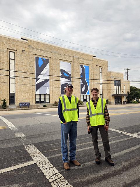 Helping the throngs safely cross a busy thoroughfare are Jansen L. Balmer (left) a residential construction technology & management student from Ephrata, and Trent B. Morrison, of South Williamsport, enrolled in concrete science technology.