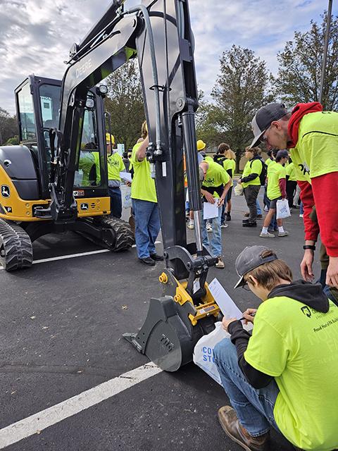 Visiting students try to identify components of a John Deere excavator at Groff Tractor & Equipment's outdoor station ...