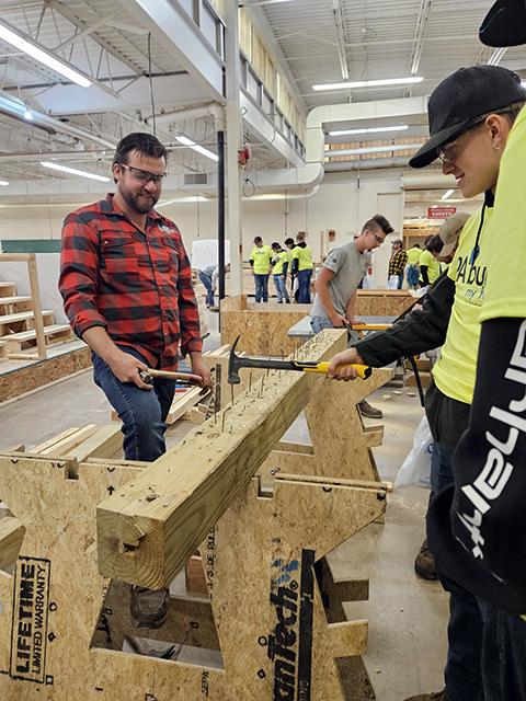 T-Ross Brothers Construction Inc. provided several competitive skill stations, including this nail-hammering exercise supervised by Cody Ross ...