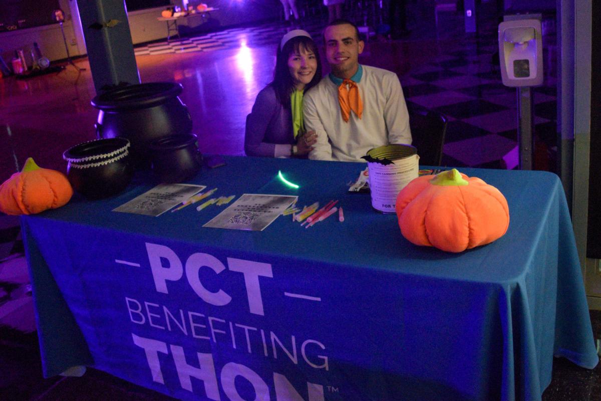 Seated with a friend at the PCT Benefiting THON table is Katherine A. Farley, of East Stroudsburg, a student engagement assistant enrolled in automotive technology: Honda PACT emphasis. THON, which raises money for the fight against pediatric cancer, co-sponsored the Wildcat Costume Party with the Office of Student Engagement.
