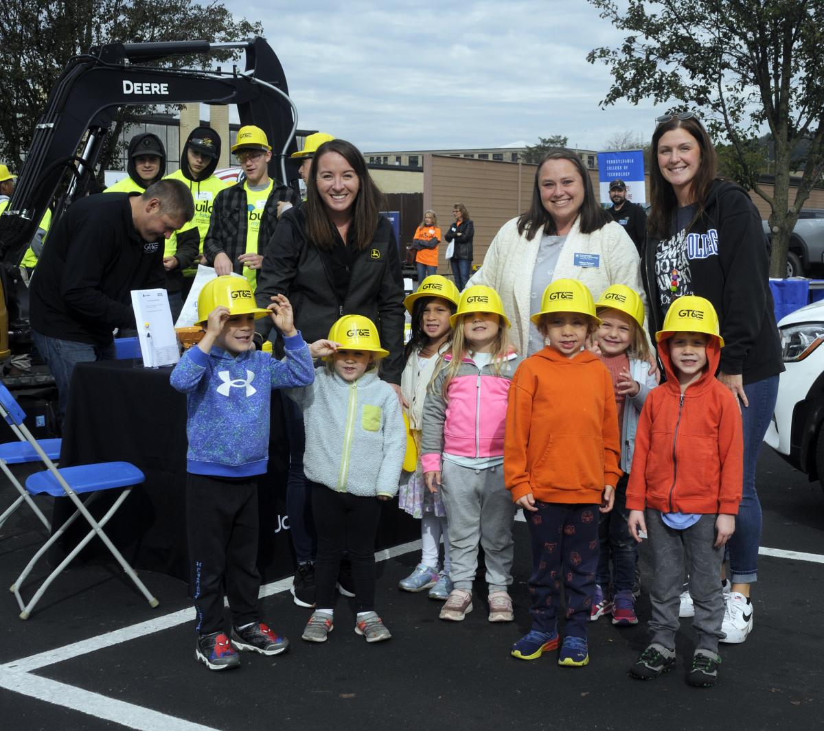 ... as Samantha O'Donnell-White (in Deere garb), GT&E's director of human resources, handed out commemorative hard hats to all – including this next-generation group of builders from the Dunham Children's Center. Accompanying the group are Tiffany L. Tyhanic (with name tag), childcare teacher, and Valerie L. Vonada, childcare assistant teacher.