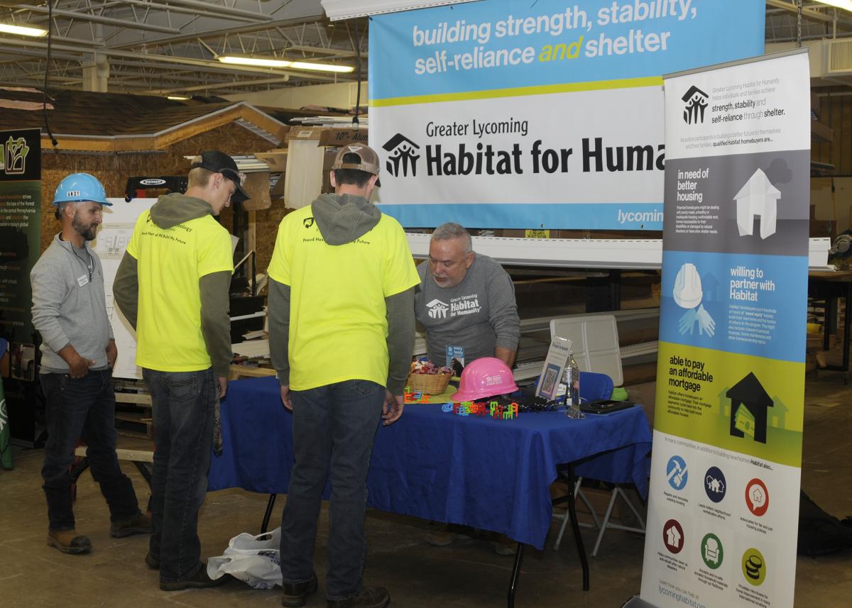 Andrew J. Hamelly (left), construction supervisor, and Robert Robinson, executive director, staff the Greater Lycoming Habitat for Humanity booth ...