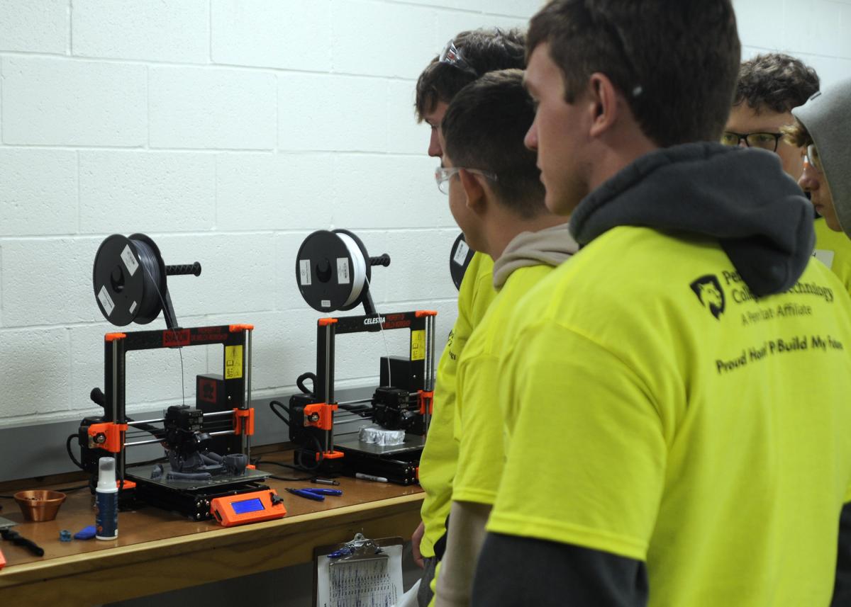 Students watch 3D printers in the Dr. Welch Workshop: A Makerspace at Penn College.