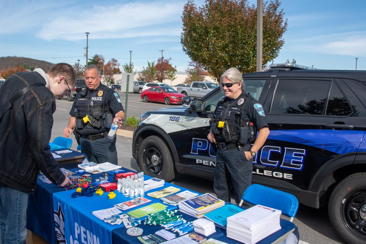 During an open house prior to the Employee Engagement event, a student interacts with David C. Pletz, chief of police and director of campus safety, and Officer Catherine J. Farr.