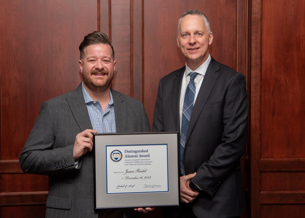 James Riedel (left), of Westville, N.J., is congratulated by President Michael J. Reed for being honored with Pennsylvania College of Technology’s Distinguished Alumni Award. Riedel is the national product training manager for Subaru of America Inc. 