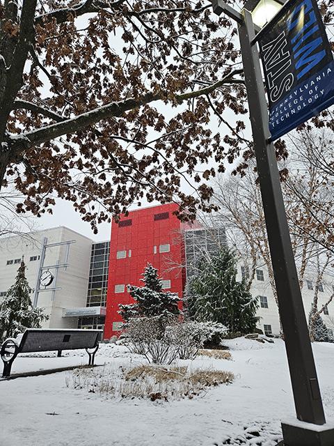 The red wall of The Madigan Library provides a vivid counterpoint to the wintry scene.