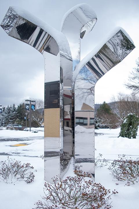 "Triad," a stainless steel sculpture outside Le Jeune Chef Restaurant, glisteningly reflects the surrounding scene.