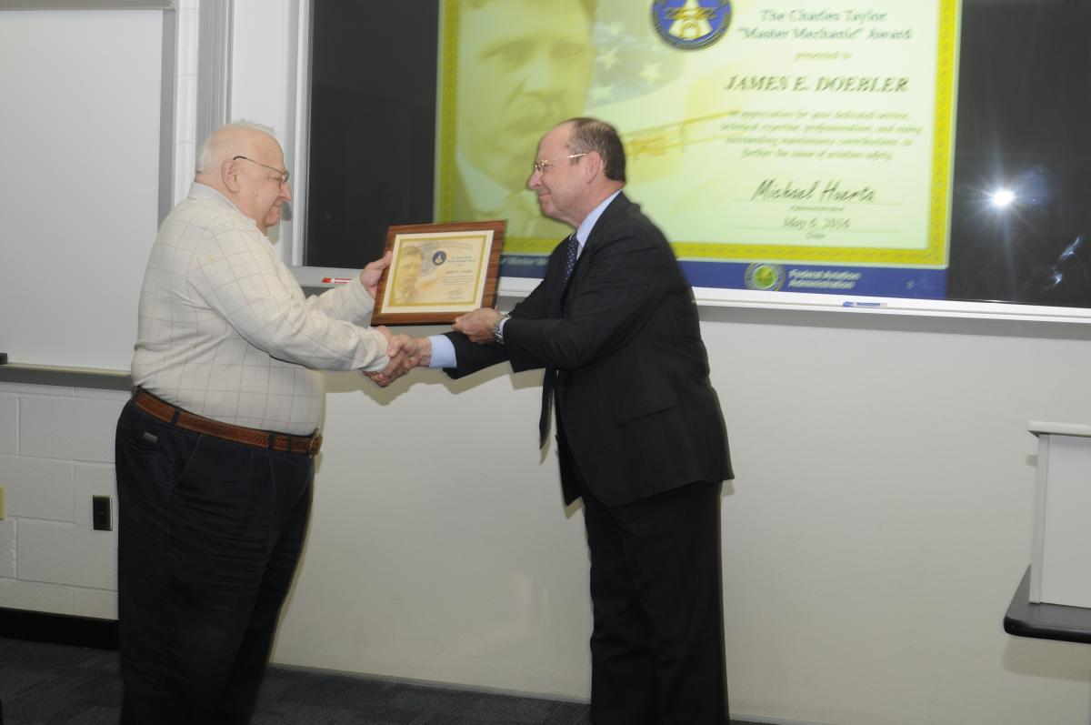 James E. Doebler receives his award from the FAA's John Sibole.