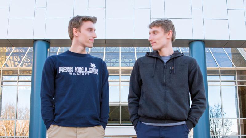 Twins Jon (left) and Jake Twardowski outside of Penn College’s Breuder Advanced Technology & Health Sciences Center, home of the polymer engineering technology program. They both earned bachelor’s degrees in polymer engineering technology – and 4.0 GPAs – in May.