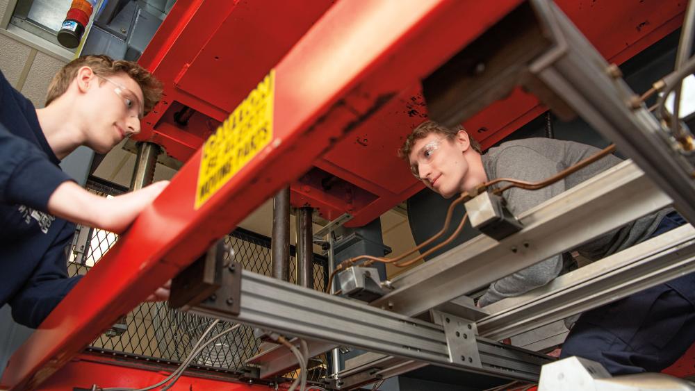 Jon (left) and Jake Twardowski enhance their hands-on education on the college’s hybrid thermoforming machine.