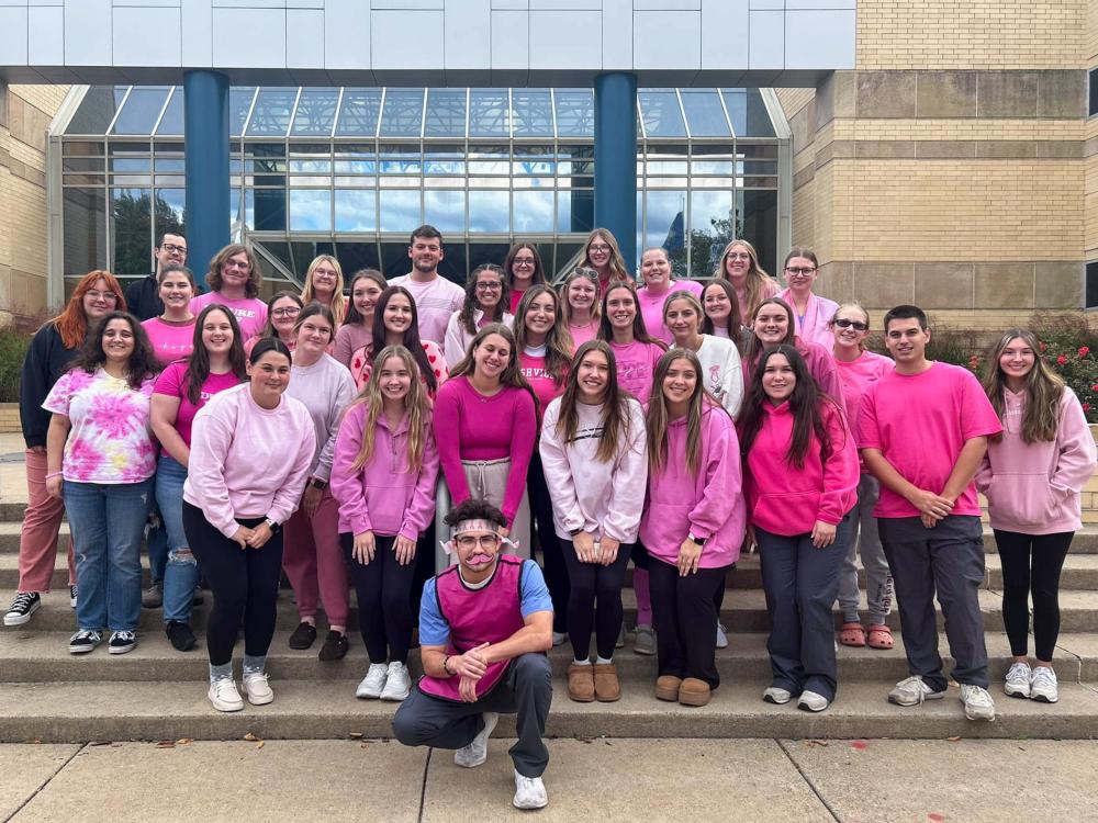 large group of club members dressed in pink