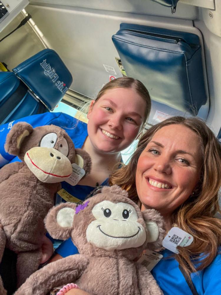 Nursing students hold stuffed monkey toys