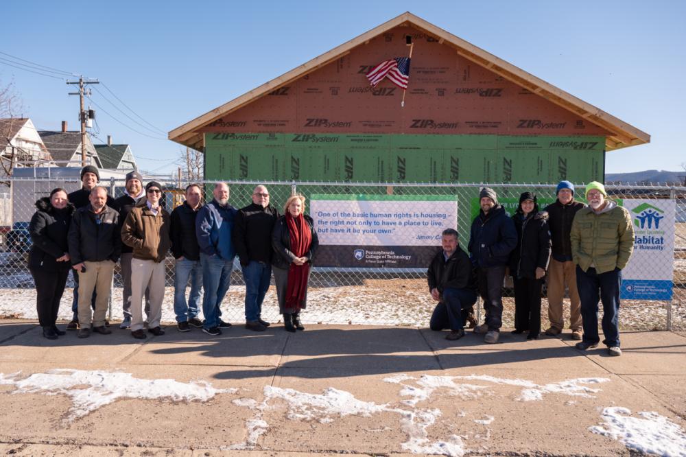 A group gathers in front of a Habitat for Humanity house being built by students at 508 Fifth Ave.