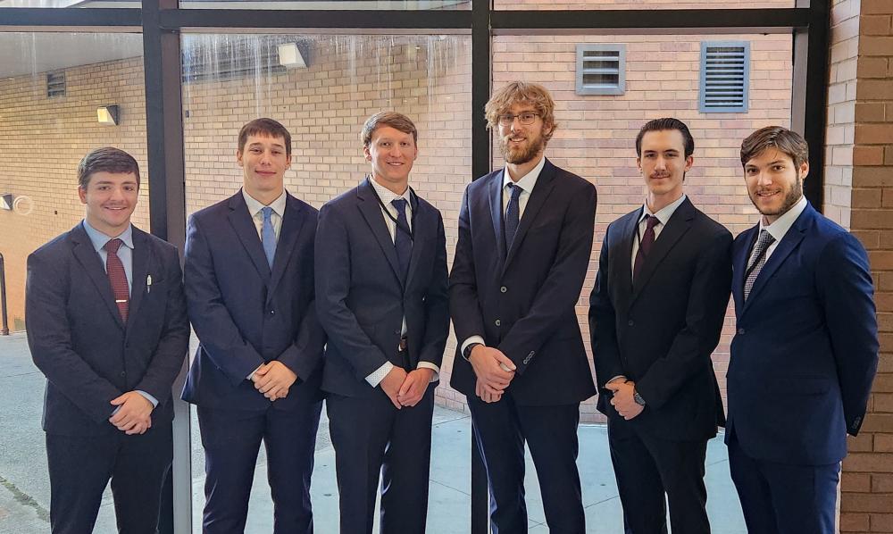 Group photo of competing students in business suits