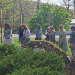 A group of employees walks by the "Mud Man," enjoying the inventive addition to the ESC's horticultural wonders.