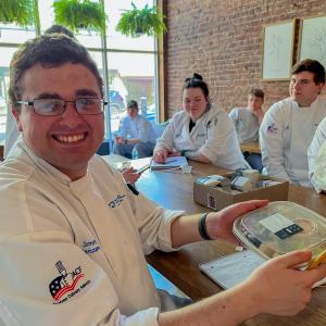 Jimmy J. Jenzano Jr., a professional baking student from Unityville, shows one of the prepackaged meals prepared by Carnie Datres and staff.