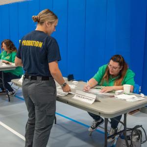 Dorenda Harmarlund (seated at right), workforce development specialist, state Department of Corrections, Board of Probation and Parole, staffs a table dedicated to logistics pertaining to child support, court fees and restitution.