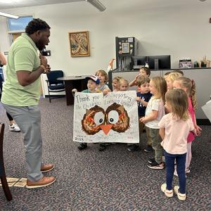 Nate Woods, special assistant to the president for inclusion transformation, reacts to the children's thoughtfulness as they visit People & Culture.