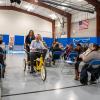 "President Mike" (with help from daughter Cali) gets into the action on an adaptive bike, much to the crowd’s delight.