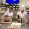 Alumna Kristina Wisneski works alongside a key mentor: Chef Michael A. Ditchfield, instructor of hospitality management/culinary arts, to toss salad greens for the first course.