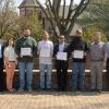 Four members of Pennsylvania College of Technology’s latest apprenticeship graduating class – part of a 12-member group that includes a number of out-of-state journeyworkers – gather with supporters near The Victorian House.