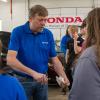 Charles F. Probst, instructor of automotive, Honda PACT, offers oil-checking guidance to a group from Seneca Highlands CTC.