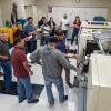 Industry professionals receive hands-on instruction from Mark A. Sneidman (foreground, in blue shirt, gesturing with pen), a member of Pennsylvania College of Technology’s plastics & polymer faculty, during the recent Injection Molding Processing Series workshop hosted by the institution’s Plastics Innovation & Resource Center. 