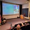 Madison L. Kistler points to some of concrete's myriad applications during a talk in the Davie Jane Gilmour Center presentation room.