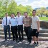 Five male students pose outdoors.