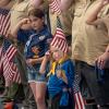 young children saluting while holding flags