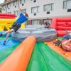 three students playing in a large inflatable game