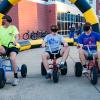 three students on large tricycles