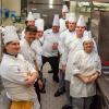 Penn College culinary students with visiting chef in kitchen