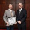 alumni award winner with plaque and college president