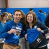 Ambassador Ryan Monteleone and Mallory L. Weymer, coordinator of student health and wellness education/suicide prevention specialist, playfully show off essential Open House swag: an activity guide and a convenient carry-all for information gathered throughout the day.