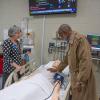 Haywood marvels at the breathing chest of a "patient" in the School of Nursing & Health Sciences, where Dean Sandra L. Richmond (left) explained the simulation aids available to nursing students.