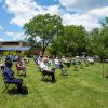 The president honors retirees, joined on the campus lawn by family members and co-workers.