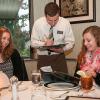 S. Jordan Stammer, center,  a student in Penn College’s culinary arts technology major, takes the dinner order of Anita K. Fink, left, and Katharina M. Sutter, both exchange students from Fachhochschule Vorarlberg in Dornbirn, Austria, during a Classical Cuisines of the World dinner in the college’s Le Jeune Chef Restaurant. The meal featured foods from the Alsace region of France, just a few hours from the students’ home university.