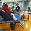 Mindy J. Colony, first-shift custodian, and Charles J. Stopper, carpenter/maintenance worker, pay valuable tribute to their late friend and GS co-worker during a blood drive in his honor. (Photo by Carl L. Shaner)