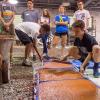 Led by Franklin H. Reber, instructor of building construction technology, and students, Career Day visitors create concrete stepping stones.