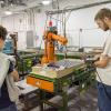 Automated manufacturing technology student Aren T. Way (right) of Jersey Shore, demonstrates an industrial-scale robot during a session on “Industrial Robotics, Hydraulics and Pneumatics, and CNC Machine Tools.”