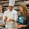 Chef Craig A. Cian, associate professor of hospitality management/culinary arts, helps a student from the Lycoming Career & Technology Center to form pizza dough.