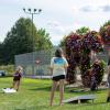 Students enjoy outdoor games against a floral backdrop.