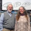 Scholarship donors and faculty members William F. Geyer and Dorothy J. Gerring with drawings from a sustainability class displayed on a wall near the architectural technology wing of the Hager Lifelong Education Center at Penn College.