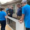 Prepping screen doors under Habitat supervision are Murren (with drill), Keyser (in glasses), Noll (in hat) and Camut.